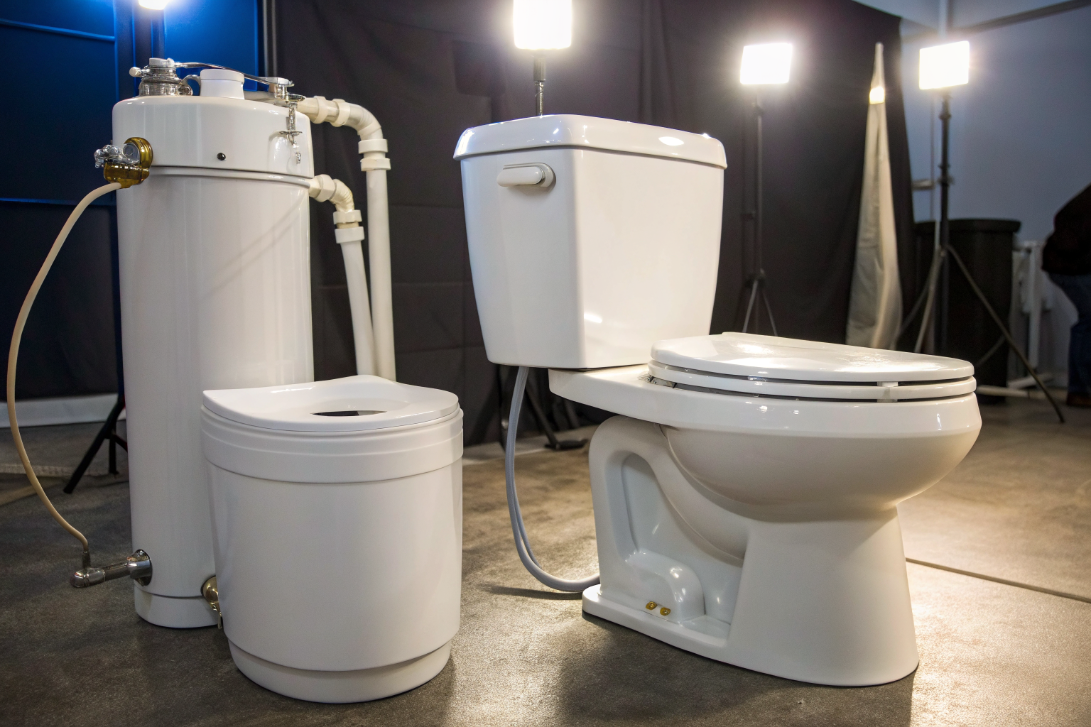 Gravity-flush and pressure-assist toilets side by side, showing mechanisms.