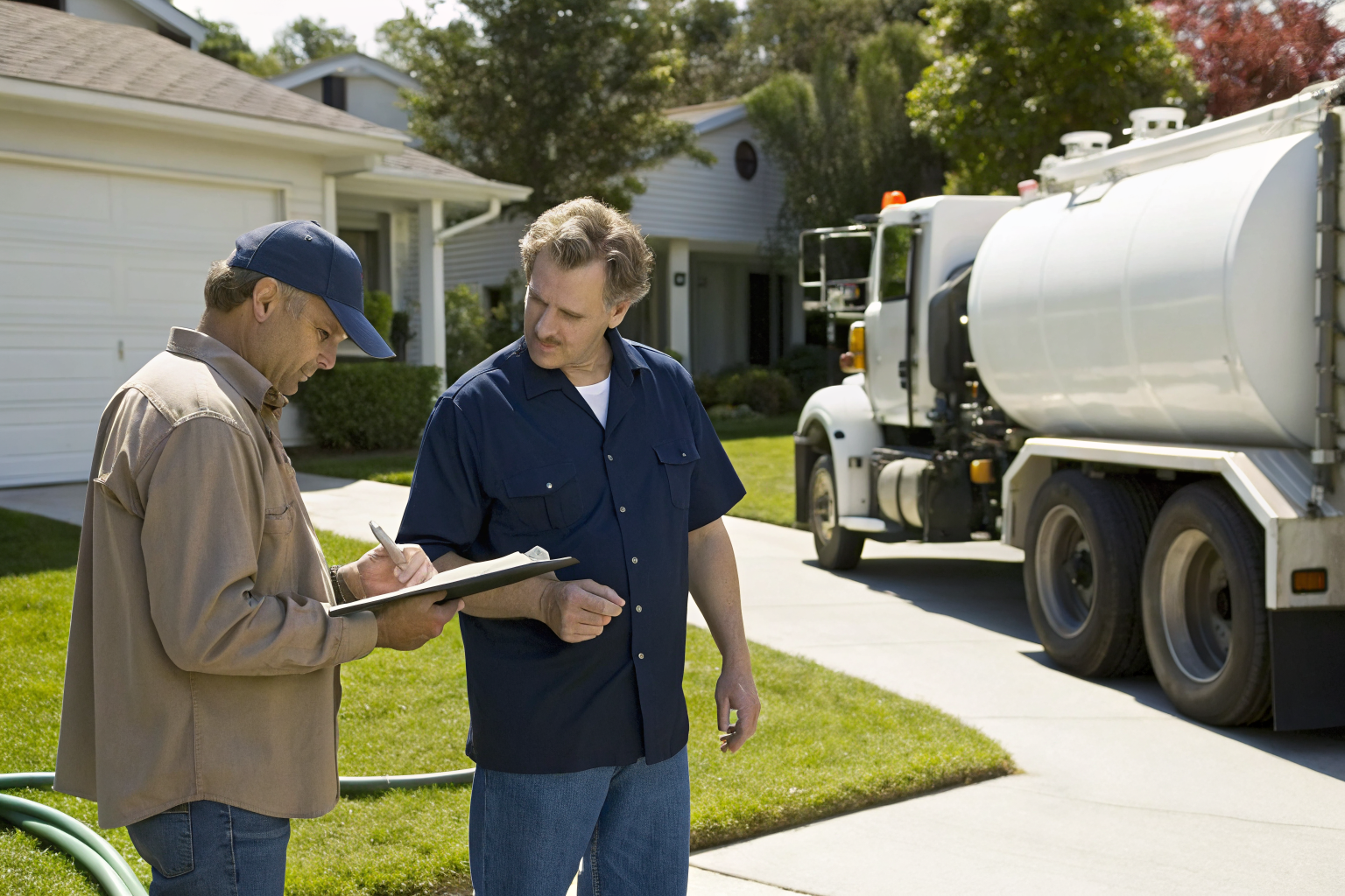 Homeowner discussing septic maintenance with pumper.