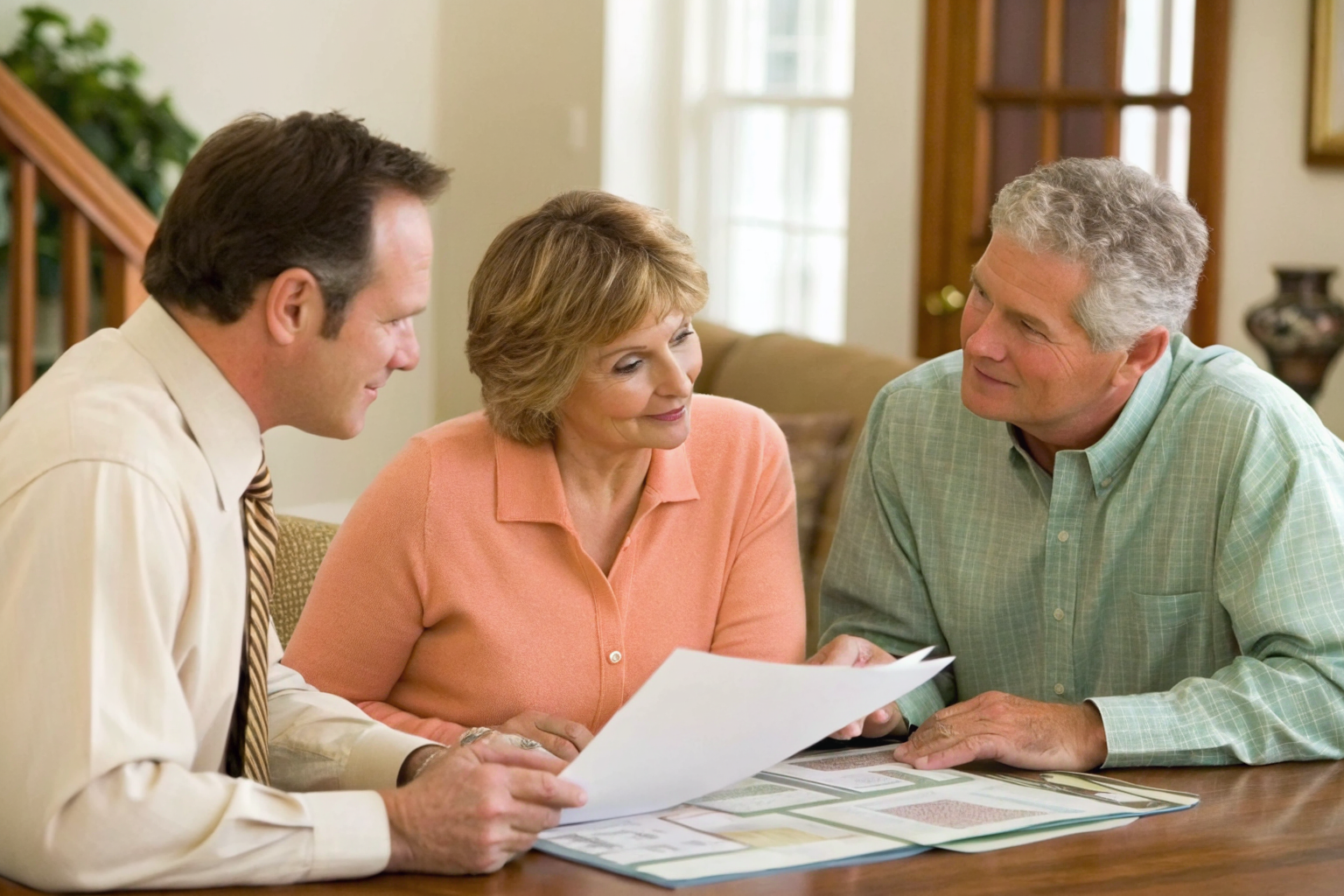 Advisor explaining upgrade program to couple at home with plans.